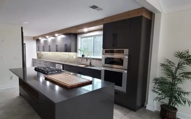 Modern kitchen with matte black flat-panel cabinets, quartz countertop, and built-in appliances.