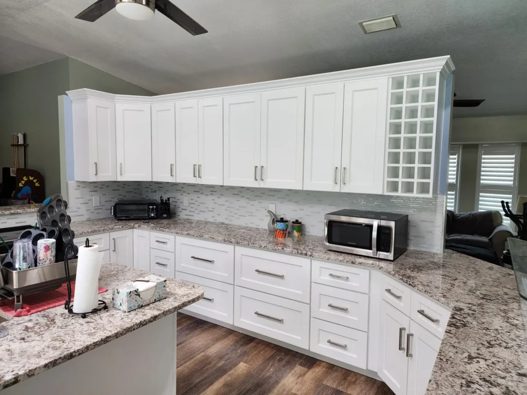 White wall cabinets above a kitchen counter with glass-front end doors