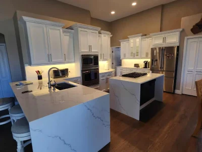 Kitchen Cabinets 21 Luxury kitchen with double islands, shaker cabinets, and waterfall-edge quartz countertops.