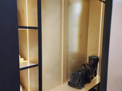Walk-in Closet 2 Custom illuminated closet with natural wood interior and matte black frame, designed for organized shoe and accessory storage.